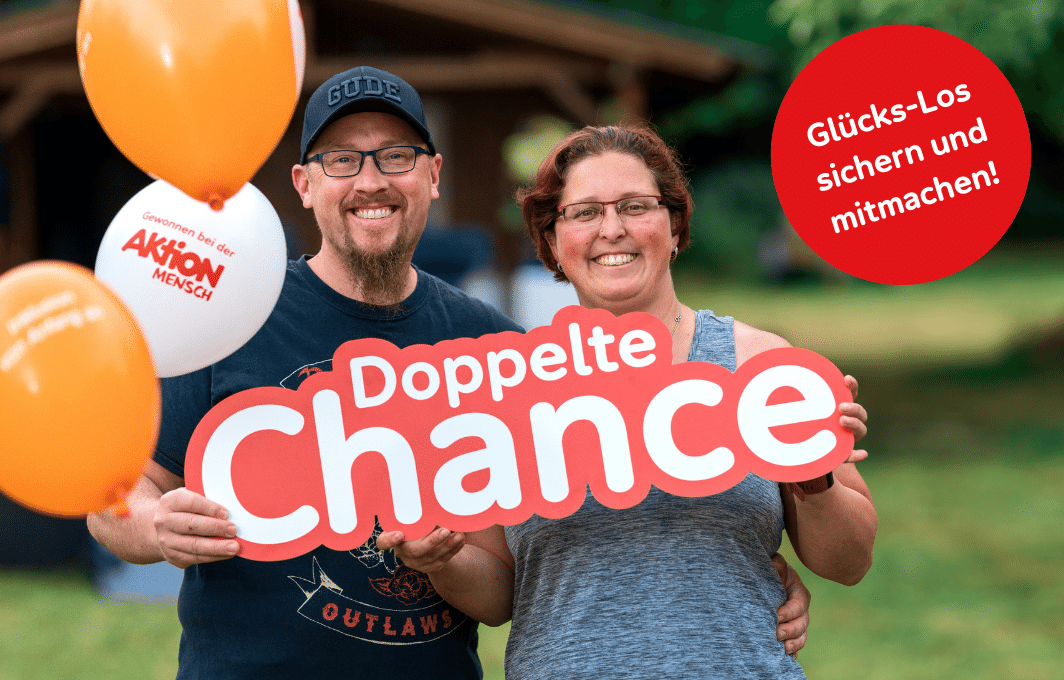 Ein Mann und eine Frau halten ein Plakat mit dem Schriftzug "Doppelte Chance" in den Händen.