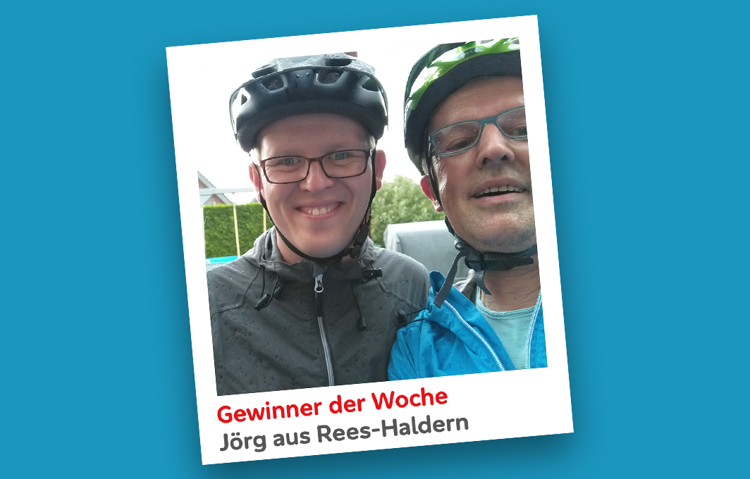 Jörg und sein Sohn haben Fahrradhelme auf und lachen in die Kamera.