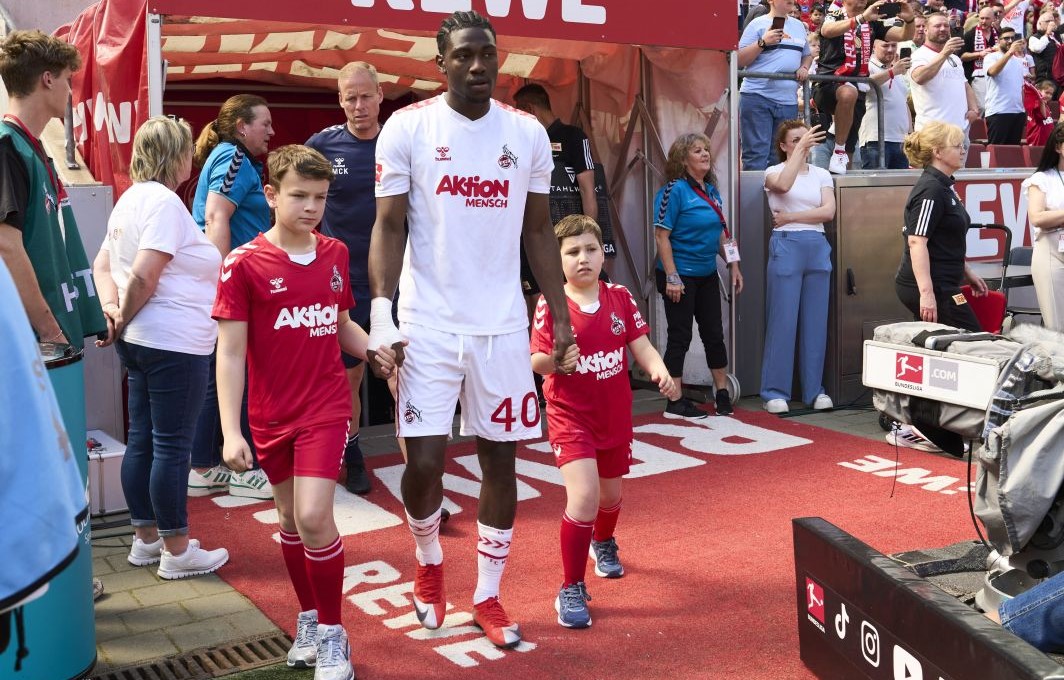 Die Spieler des 1. FC Köln laufen gemeinsam mit je zwei Kindern ins Stadion ein.